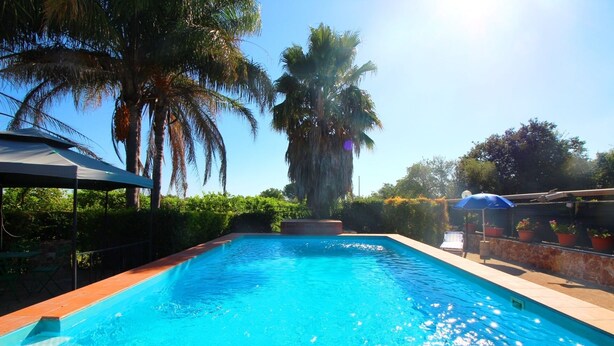 A rectangular swimming pool with clear blue water, surrounded by a tiled deck. - Monasteri Rural Holiday Home (Sicilia)