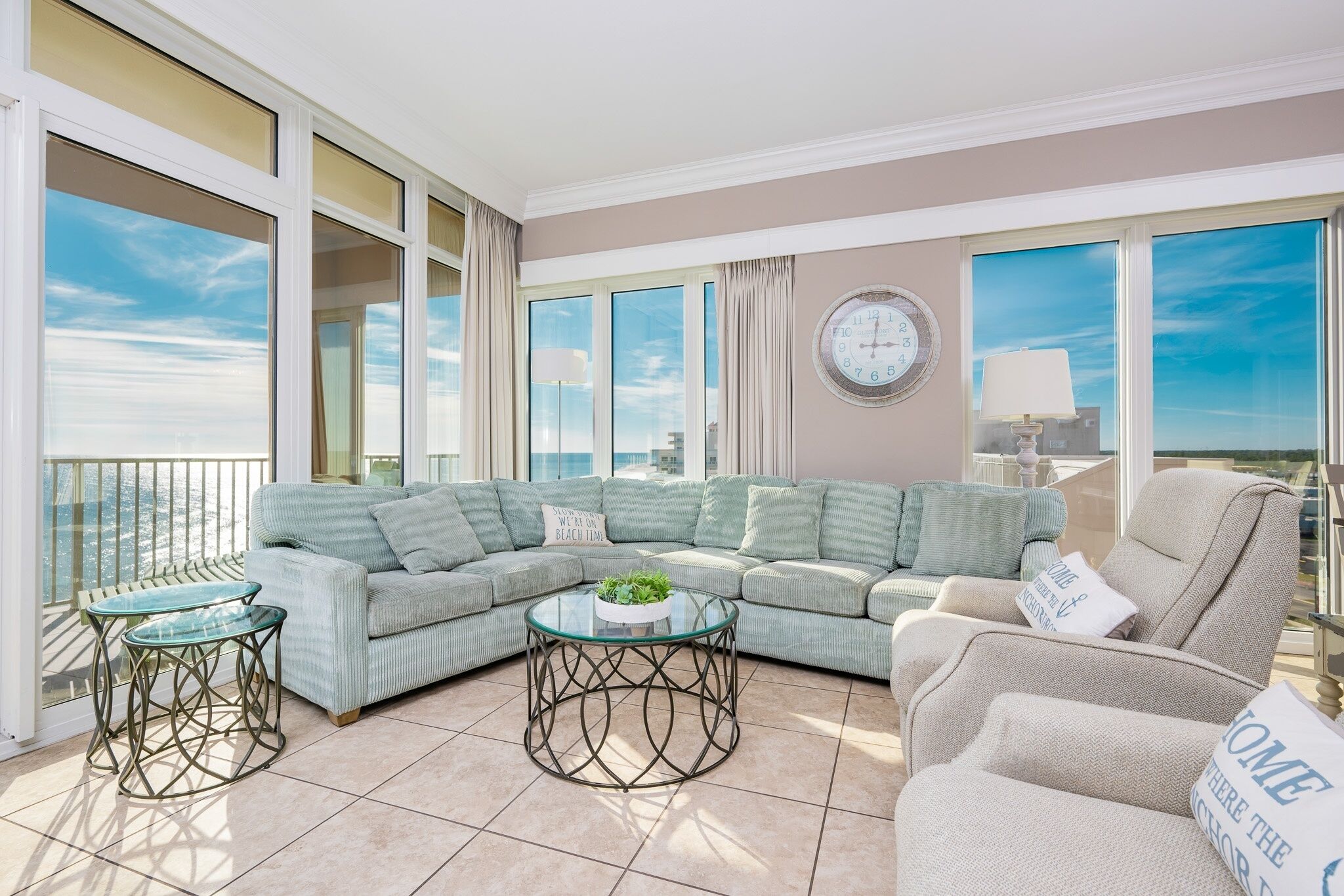 Amplia sala de estar con sofá modular, mesa de centro de vidrio y vista panorámica de la ciudad.