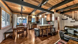 A spacious kitchen with wooden beams, a dining area with wooden chairs, and a leather sofa. - Coh0809 - Brule Haven 3 Bedroom Home (South Lake Tahoe)