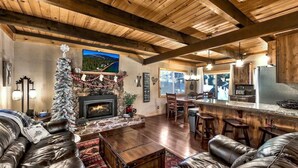 A cozy living room with a fireplace, leather sofas, and a Christmas tree. - Coh0809 - Brule Haven 3 Bedroom Home (South Lake Tahoe)