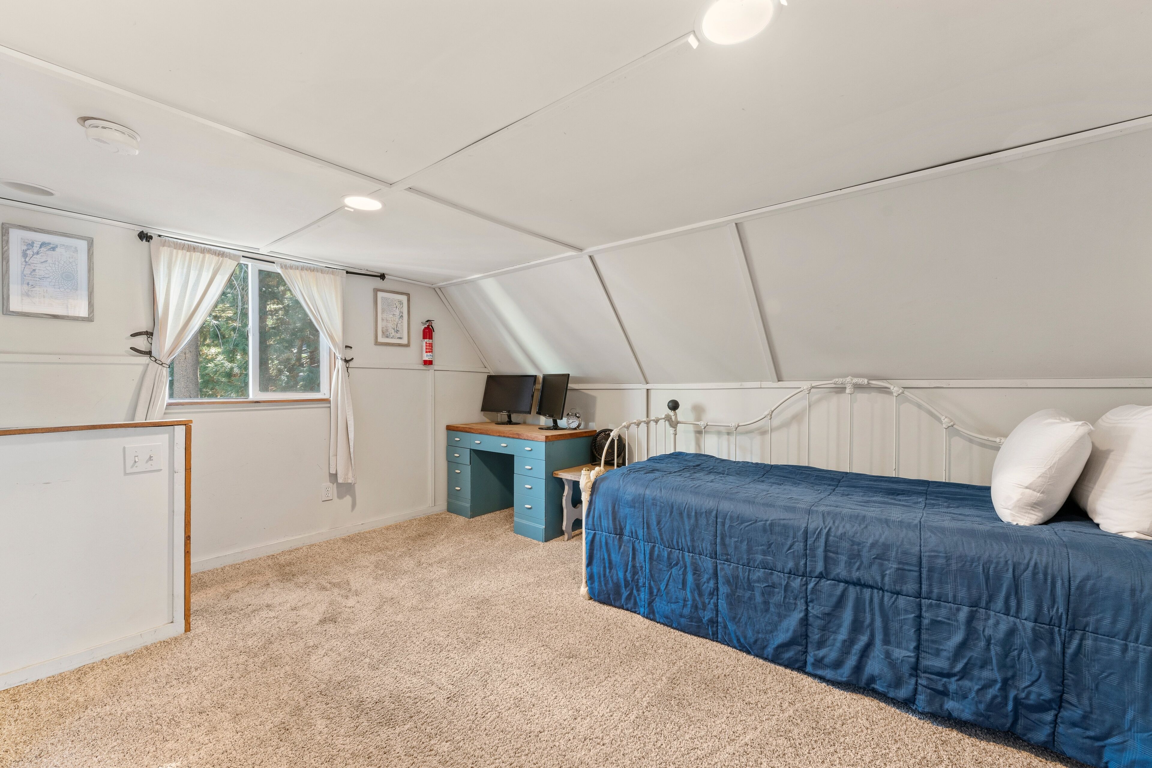 Een slaapkamer met een bed, een bureau, een stoel, een radiator en een raam.