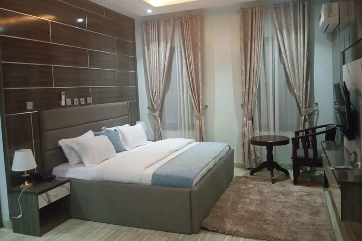 Una camera da letto moderna con un letto grande, comodini, un tavolino rotondo e una TV.
