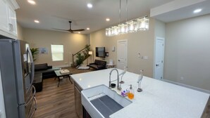 A modern kitchen with a large island, built-in appliances, and a dining area with a sofa and table. - 200 Steps To Beach Private Pool 2 Big Levels 3 Bedroom Apts (South Padre Island)