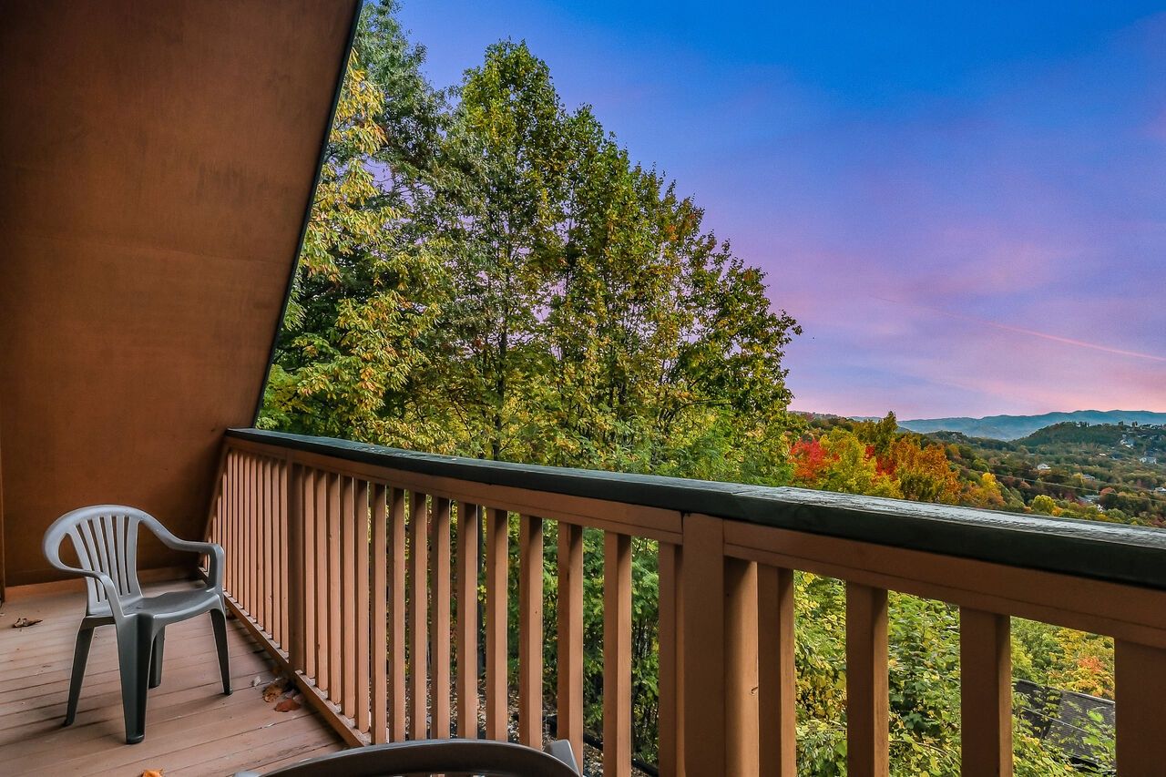 A balcony with a view of a forested landscape.