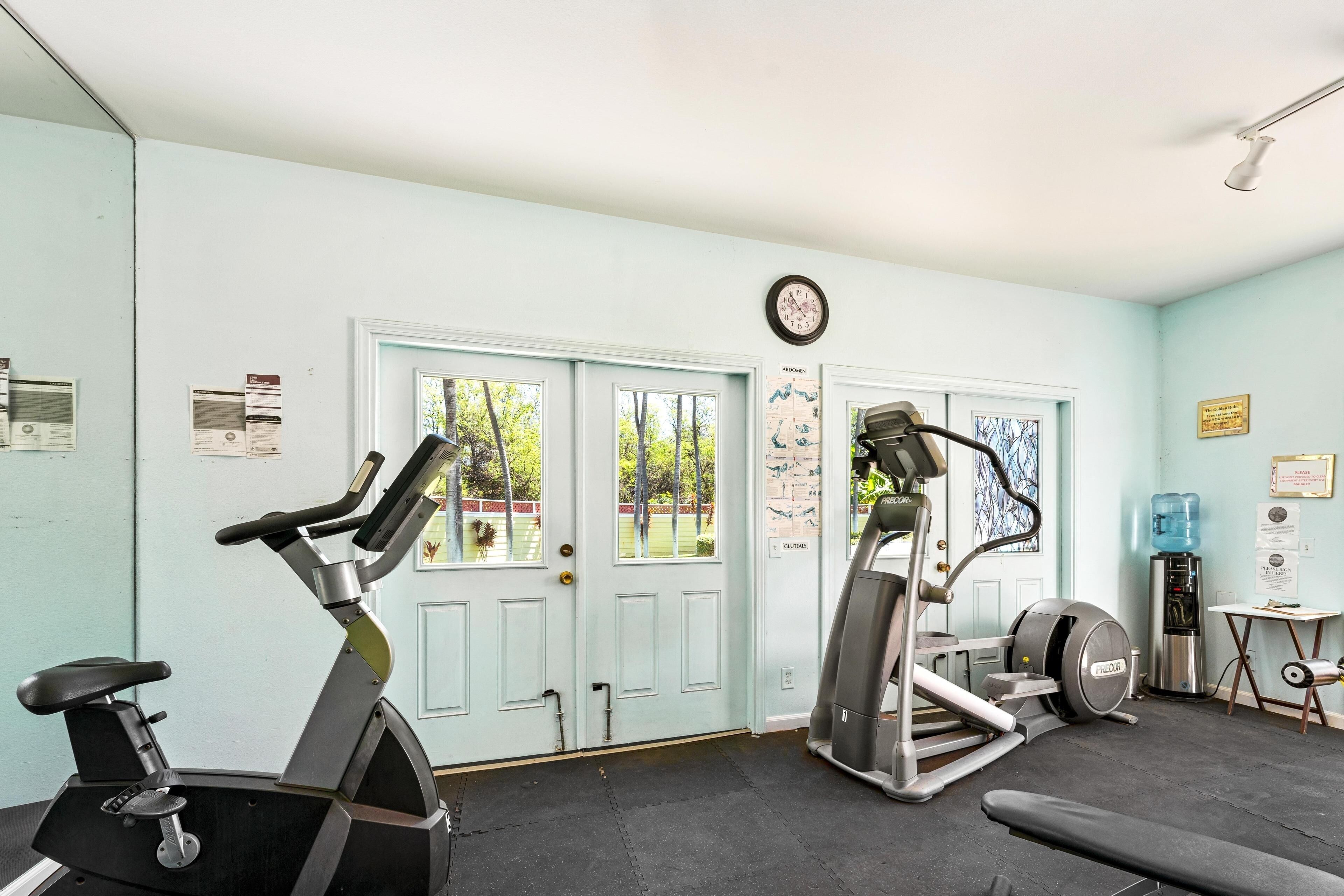 A gym with stationary bikes, a treadmill, and a water dispenser.