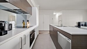 Een moderne keuken met witte kasten, roestvrijstalen apparatuur en een centraal eiland.