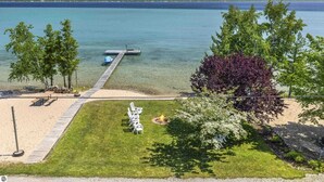 Una proprietà sul lago con un molo, aree verdi e alberi.