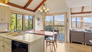A spacious kitchen with a large island, wooden flooring, and a view of the outdoors. - “High Haven — A Modern Mountain Retreat with Breathtaking Views” (Sugar Mountain)