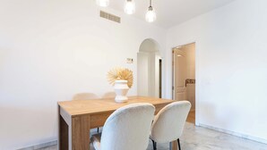 A dining area with a wooden table, two upholstered chairs, and a decorative vase. - SR Ground floor flat with direct access to the pool! (Marbella)