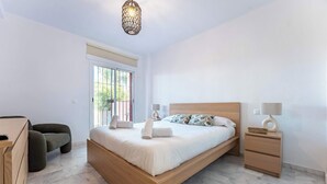 A modern bedroom with a wooden bed, bedside tables, a desk, and a chair. - SR Ground floor flat with direct access to the pool! (Marbella)