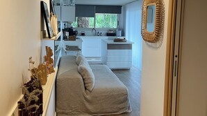 Eine moderne Küche mit weißen Schränken, einem eingebauten Backofen und einem Fenster mit Blick ins Grüne.