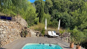 Ein rechteckiger Swimmingpool mit klarem, blauem Wasser, umgeben von einer Holzterrasse.