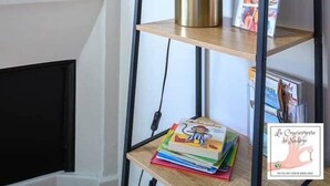 Een boekenplank met een bloemenvaas, een lamp en boeken.