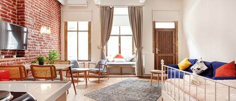 Economy Studio | Desk, laptop workspace, blackout drapes, iron/ironing board