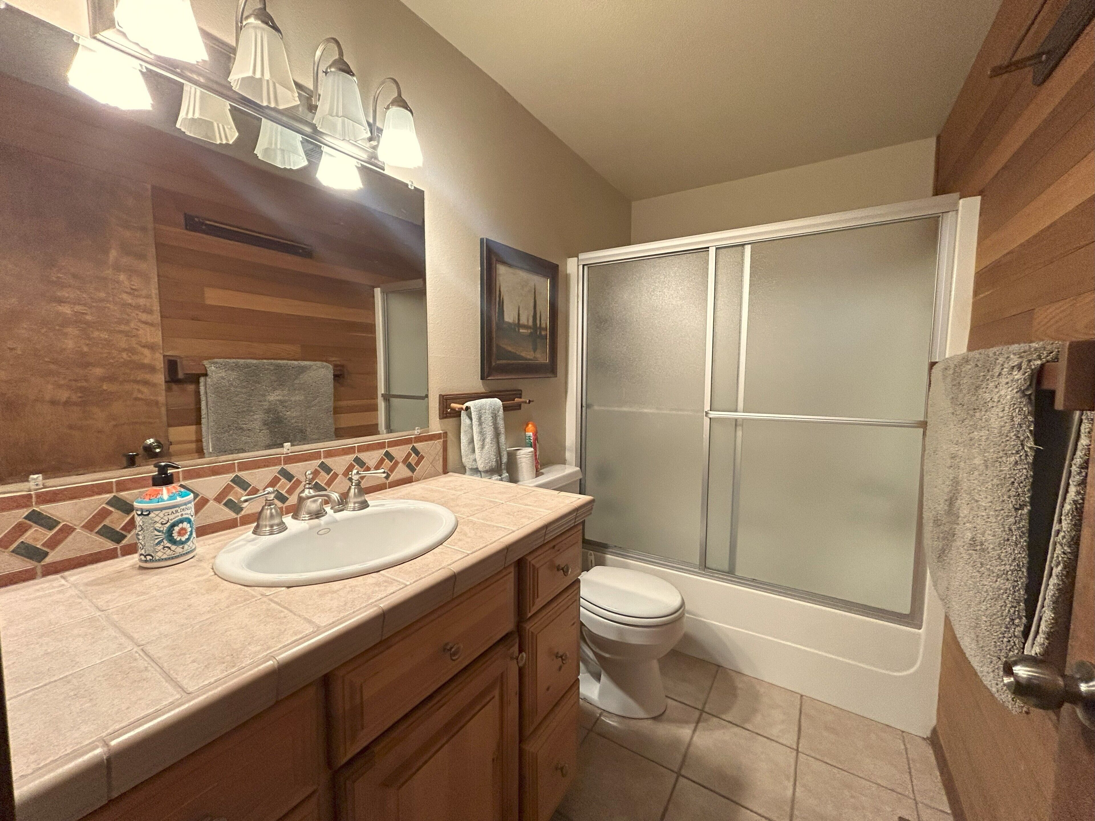 A bathroom with a sink, toilet, and shower.