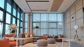 A modern interior with a sectional sofa, round ottomans, and a round table.