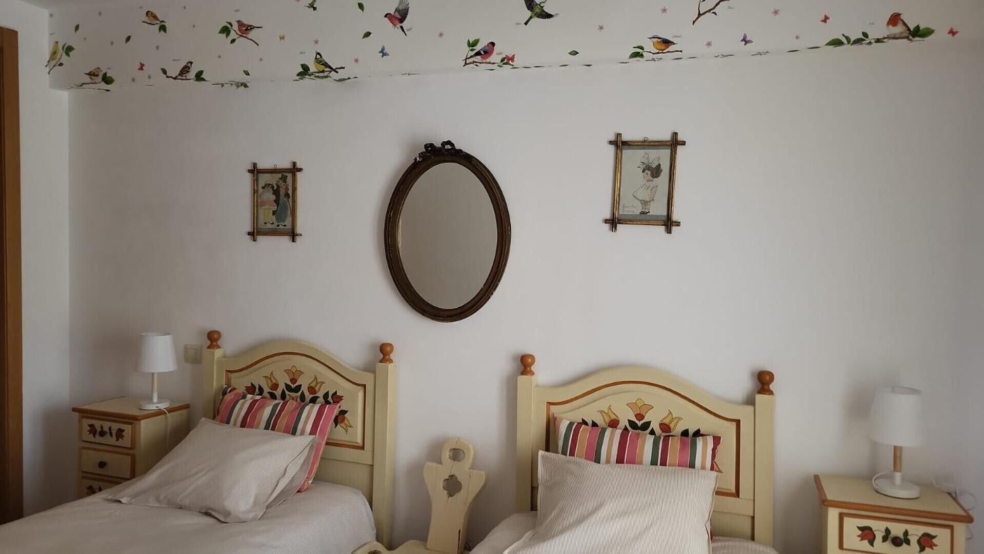 Un dormitorio con dos camas, un espejo y adornos en la pared.