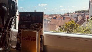 A kitchen window with a view of a town, a book titled 'Das Kleine Kochbuch', and kitchen utensils. - Detached single-family home above the rooftops of Bad Dürkheim (Bad Dürkheim)