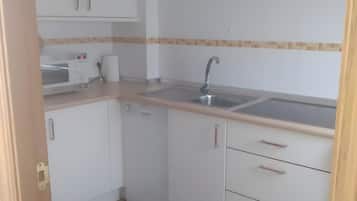 Een koelkast, een magnetron, een kookplaat, een vaatwasser