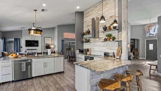 A spacious kitchen with a large island, modern appliances, and a rustic wooden accent wall. - LUX Modern Escape: Pool, Putt, Kierland Commons (Scottsdale)