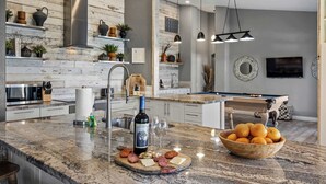 A modern kitchen with a marble countertop, a built-in wine cooler, and a pool table. - LUX Modern Escape: Pool, Putt, Kierland Commons (Scottsdale)