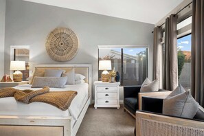 A modern bedroom with a large bed, a bedside table with lamps, a decorative wall piece, and a view of the outdoors through a large window. - LUX Modern Escape: Pool, Putt, Kierland Commons (Scottsdale)