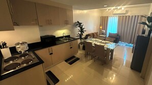 Una cocina moderna con zona de comedor, que cuenta con una isla grande, electrodomésticos integrados y un espacio para sentarse.