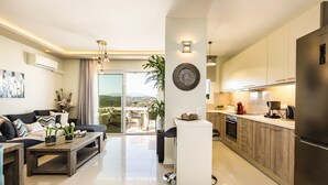 Un appartement moderne comprenant un espace de vie, une cuisine et un balcon avec vue.