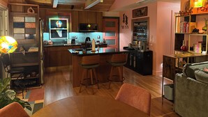 Una cucina accogliente con mobili in legno, un'isola centrale e un'area pranzo con tavolo e sedie.