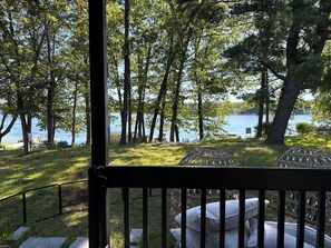 A view from a balcony overlooking a lake with trees and a grassy area. - Mid-century marvelous 2-bedroom bungalow with lake views in Southwick (Southwick)
