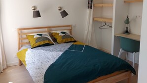 A bedroom with a wooden bed, a desk with a chair, and a hanging lamp. - Ty PenAr Pont étage (Saint-Pol-de-Léon)