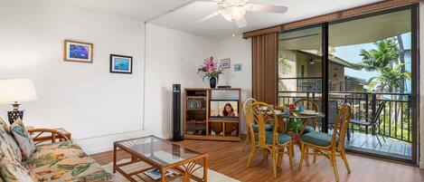A spacious living area with a balcony, a ceiling fan, and a view of the outdoors.
