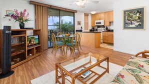 A modern apartment with a dining area, kitchen, and a balcony with a view. - Great Location AC & Wifi Concierge Included! (Kailua-Kona)