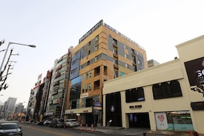 A multi-story hotel with a modern design, featuring a prominent entrance and a visible sign for a spa. - Bolton Hotel (Gwangju)