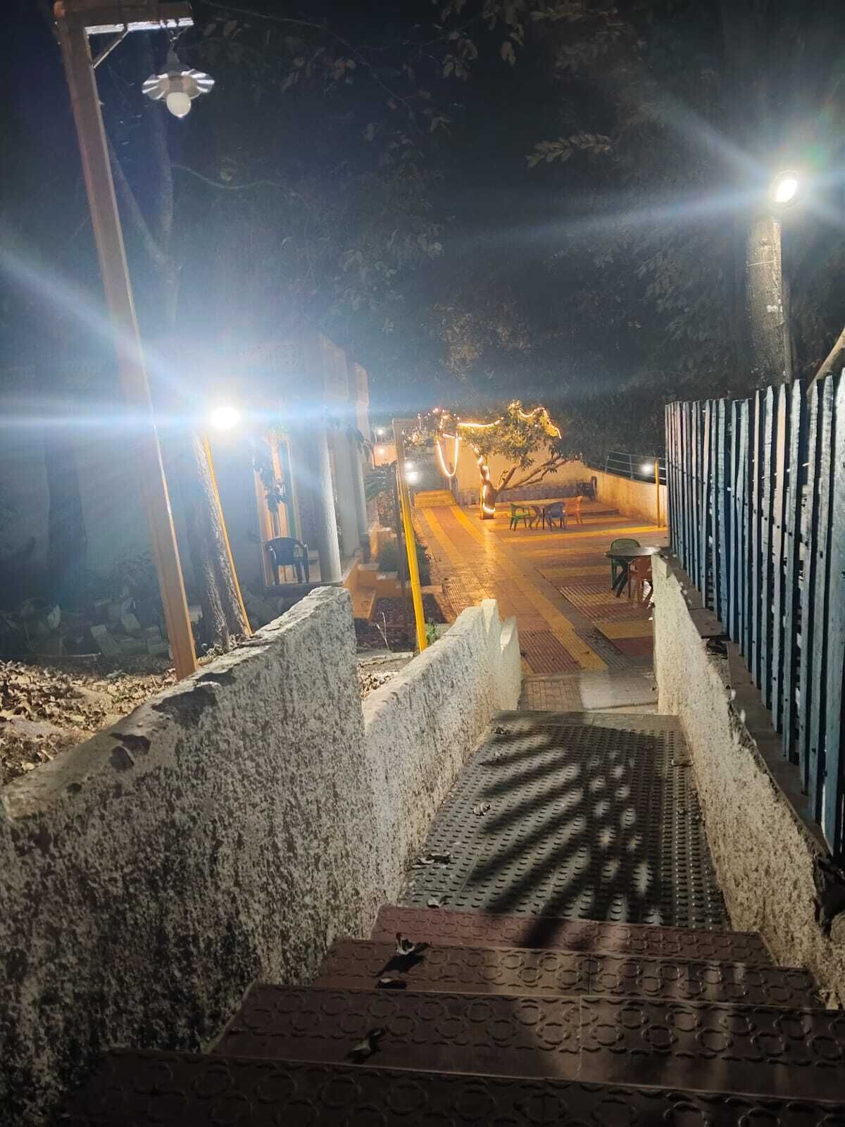 Een buitentrap 's nachts met metalen leuningen en een betonnen muur.
