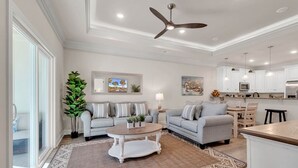 A spacious living room with two sofas, a coffee table, and a large window. - Yellow Fin Retreat (Murrells Inlet)