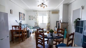 Un coin repas avec une table ronde, des chaises en bois et un ventilateur de plafond.