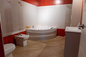 Une salle de bain moderne avec une baignoire sur pieds, des toilettes et un lavabo.