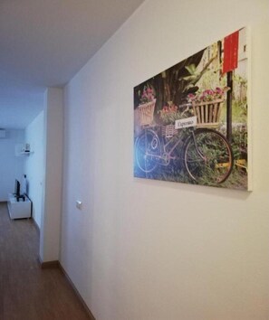 Ein Flur mit einem Wandbild von einem Fahrrad mit Blumen und einem Schild mit der Aufschrift 'Espresso'.