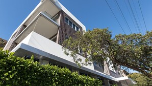 A modern building with a sloped roof, large windows, and a brick facade. - Cosy 1-bedroom Apartment Close to the City (Sydney)