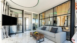 Un salon moderne avec un canapé, une table basse et un téléviseur.