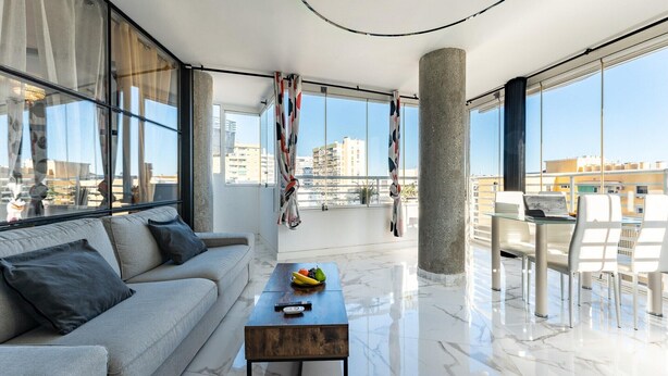 Un salon moderne avec un canapé, une table basse et un coin repas.