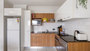 Eine moderne Küche mit weißen Schränken, einer eingebauten Mikrowelle und einem Toaster.