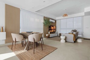 Una sala de estar moderna con comedor, un sofá y una televisión.