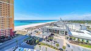 A coastal hotel with a beach view, a pier, and a parking area. - ☀️Panoramic Gulf and Pool Views-Steps to Beach-Calypso 3-1006☀️ (Panama City Beach)