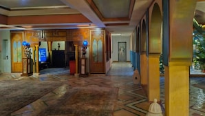 A spacious lobby with a patterned floor, wooden columns, and a reception desk. - Palais Oussoud Marrakech (Marrakech)
