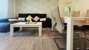 Una sala de estar moderna con un sofá, una mesa de centro y un comedor con sillas y una mesa.