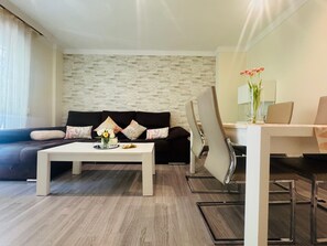 Una sala de estar moderna con un sofá, una mesa de centro y un comedor con sillas y una mesa.