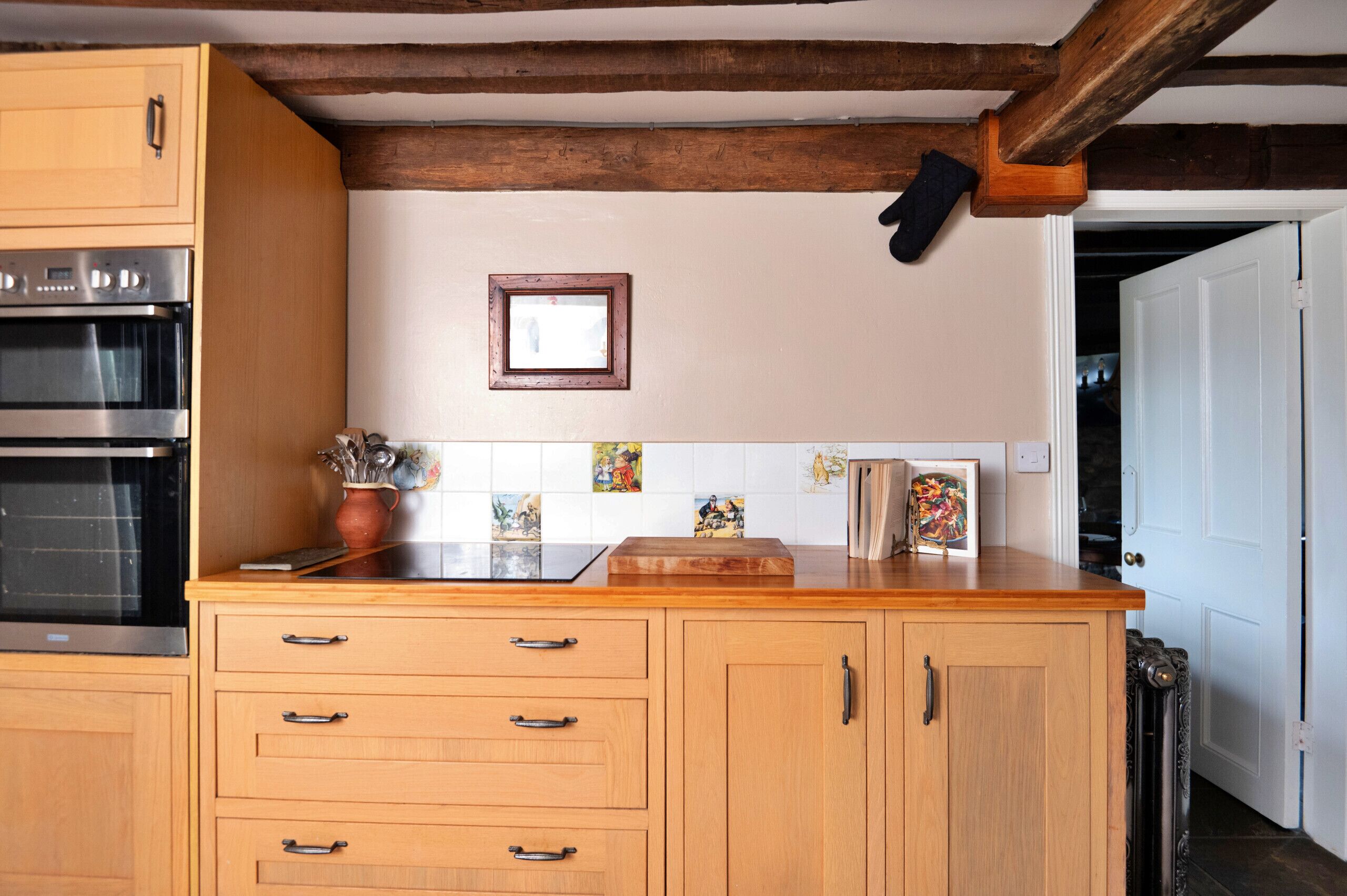 A kitchen with wooden cabinets, a built-in oven, and a tiled backsplash.