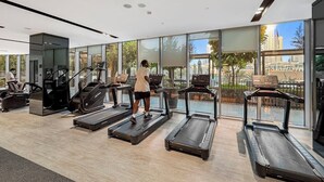 Ein modernes Fitnessstudio mit Laufbändern, einem Ergometer und einem Krafttrainer.
